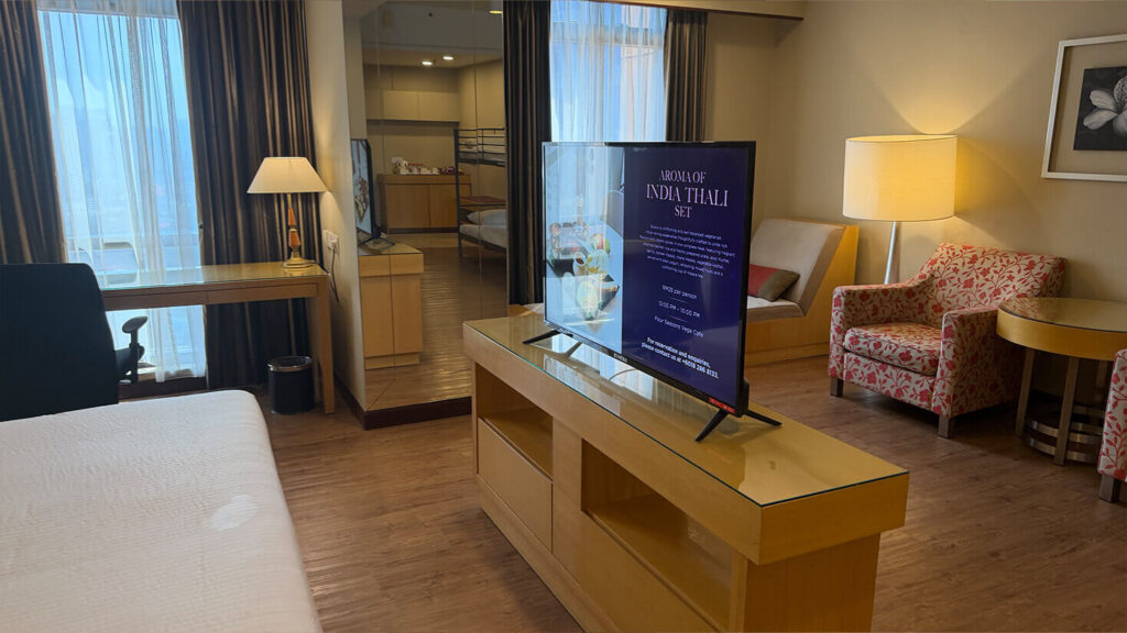 The apartment-style layout also includes seating, a television and a dining or work area.