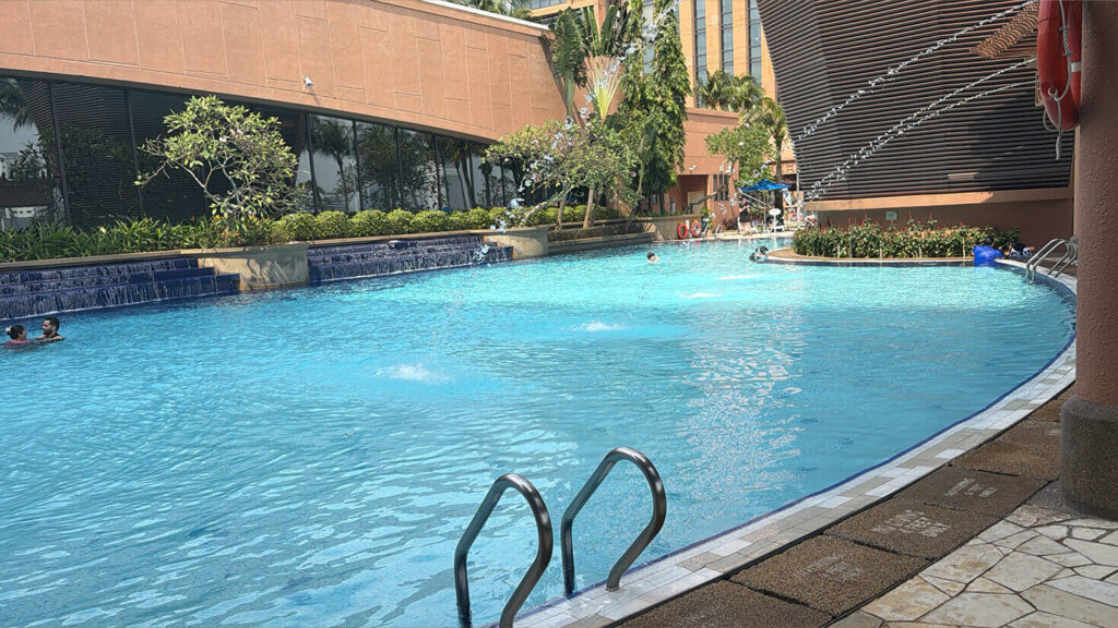 The large outdoor pool features water jets, cascades and tropical landscaping.