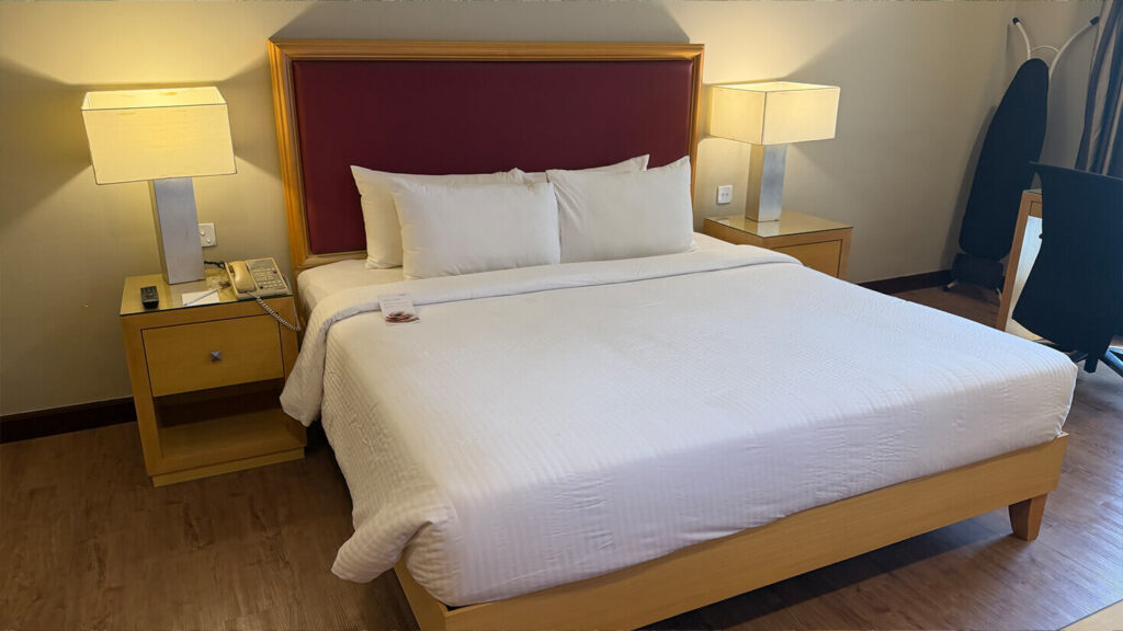 The main sleeping area is generously proportioned, with comfortable bedding and bedside lighting.